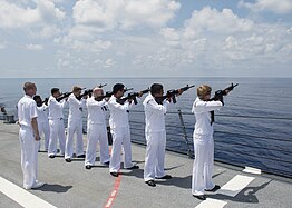 Sailors aboard the Arleigh Burke-class Destroyer USS William P. Lawrence (DDG 110) render a Three-volley salute during the Memorial Day ceremony in honor of Keating.