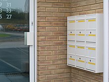 A photograph of a bank of wall mounted post boxes used in a private residence in the United Kingdom.