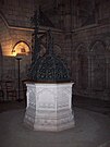 Fonte battesimale in pietra della cattedrale, sormontato dalla sua copertura in ferro forgiato dal fabbro Ferdinand Marrou (1836–1917), nella sala bassa della torre