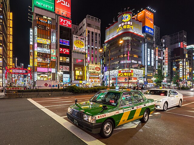 Green_and_yellow_taxi_at_night_in_Yasukuni-dori_Avenue,_Shinjuku,_Tokyo