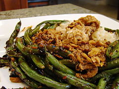 A dish with green beans, rice, and soy curls. The soy curls look brown in color, a bit like small pieces of broken chicken.