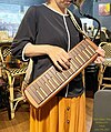 木製の鍵盤ハーモニカ「SUZUKI W-37」を立奏する女性。木は高音の倍音を吸収し抑える効果があるため、プラスチック製の鍵盤ハーモニカと一味違う音色を楽しめる。