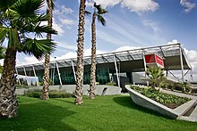 Airport terminal, with four trees in the foreground