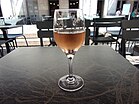 Photographie en couleurs d'un verre de vin rosé.