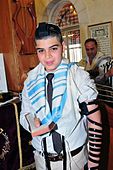 Gutt med bønneremmer og tallit (bønnesjal) under feiring av bar mitzvah i Maoz Zion i Israel 2011