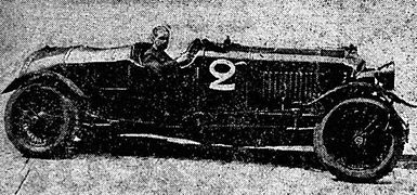 Photo de profil d'une voiture avec son pilote à bord, prenant la pose.