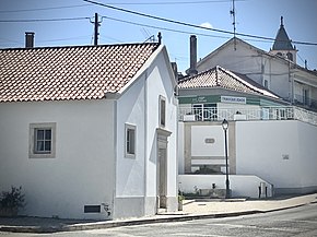 Capela do Senhor Bom Jesus dos Aflitos em primeiro plano; torre sineira da Igreja de Nossa Senhora de Fátima ao fundo