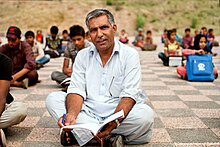 Ayub sitting among his students at a park in Islamabad in 2016