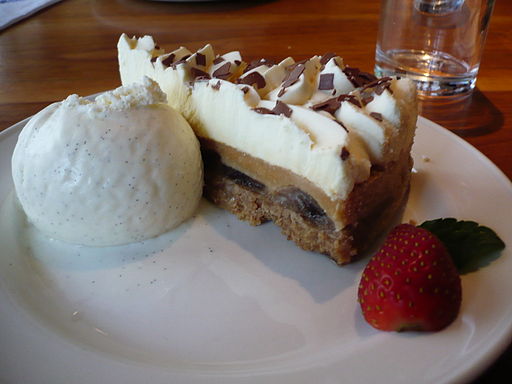 Slice of banoffee pie with vanilla ice cream and strawberries