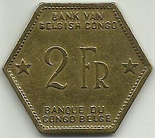 Une pièce jaune hexagonale portant les mentions « Bank van Belgisch Congo. 2 Fr. Banque du Congo belge. »
