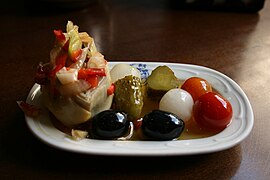 Alcachofa rellena con encurtidos y tomates cherry.