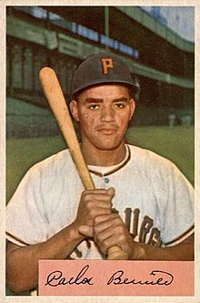 A man in a white baseball jersey and black cap