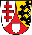 Stadt Neutraubling Durch eine eingeschweifte rote Spitze, darin ein silberner Leerschild, gespalten von Silber und Gold; vorne ein rotes Patriarchenkreuz, hinten ein aus dem Schildrand wachsendes schwarzes Zahnrad.