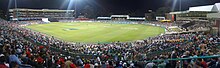 A panoramic view of a crowded sports stadium at night