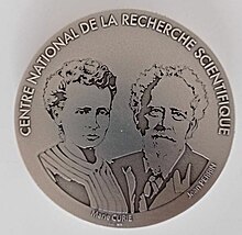 Exemple de médaille d'argent du CNRS. La médaille présente deux physiciens, Marie Curie et Jean Perrin.