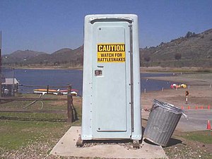 Porta-potty with rattlesnake warning sign at L...