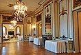 An empty wood-floored room with ornate grey and gold walls