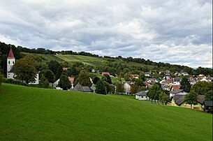 Heiligenbrunn vom Pfarrriegel aus gesehen: Links die Pfarrkirche mit der Ulrichskapelle, hinten die Weingärten am Stifter- und Hochberg