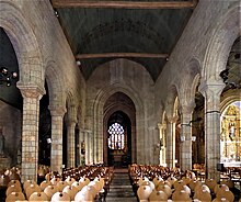 Photographie d'un intérieur d'église avec une nef séparée du transept par un arc triomphal imposant
