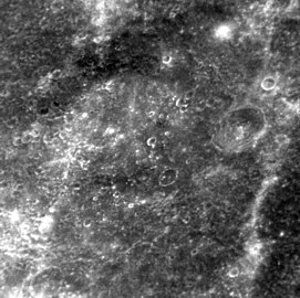 Molière crater at a high sun angle. The crater is barely distinguishable due to high sun angle and lack of shadows. The southern rim is in the lower left corner.