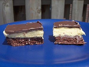 Two nanaimo bars on a blue plate