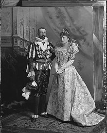 Man and woman in elegant costume with edges of the false background showing