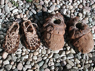 Rekonstruktion der Ötzi-Schuhe: Das Innengeflecht aus gezwirnten und gedrehten Schnüren aus Lindenbast, die Außenschuhe aus Hirschfell mit Bärenfellsohle. Eine Isolierschicht aus trockenem Gras wird durch ein Innengeflecht aus gezwirnten und gedrehten Lindenbastschnüren rundum im Schuh festgehalten.