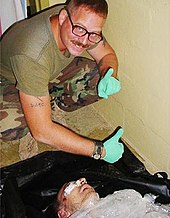 Charles Graner poses over Manadel al-Jamadi's corpse, after he was tortured to death by CIA personnel. AbuGhraibScandalGraner55.jpg