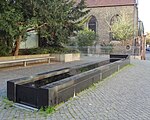 Brunnen an der Schützenstraße, im Hintergrund die Bartholomäuskapelle