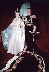 Elizabeth portant une robe et une couronne aux côtés de son époux en uniforme militaire.