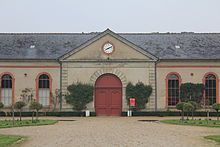 Un grand bâtiment avec une horloge au-dessus de l'entrée