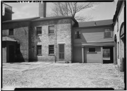 Patio trasero que muestra el alerón trasero de la casa, 1958