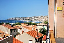 Vue en plongée sur des toits de maisons et la mer en arrière-plan