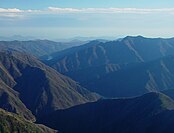 東海道の平野と赤石山脈の対比。田中清一は国土の2割にひしめく人口と産業を未利用の8割の山岳部に分散することを謳う[221]。しかし、国土の2割しかない平野に人口と都市が集中するのにはそれなりの理由がある。逆に山岳地帯が未利用のまま残されているのは、地形が険しいために生産にも生活にも能率が上がらないからである[87][注釈 10]。このため田中や中央道派が唱える山岳地帯への人口・産業・都市の再配置計画は非現実的であると専門家はいう[5]。