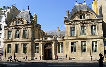 Portail cocher[12], dressé contre un corps bas en terrasse (disposition restituée lors de la restauration en 1950-1970) et qui donne accès à la cour pavée[13].