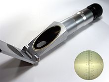 A small cylindrical refractometer with a surface for the sample at one end and an eye piece to look into at the other end
