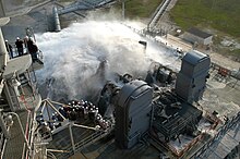 Workers and media witness the Sound Suppression Water System test at Launch Pad 39A Sound suppression water system test at KSC Launch Pad 39A.jpg