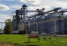 sign reading "Beltrami established 1883". In the background, grain silos and grain elevators are visible.