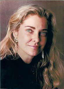 head and shoulders photo of a woman with long blonde hair and darker eyebrows