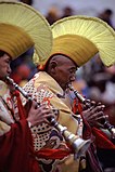 Gelugmunkar som spelar traditionella blåsinstrument.