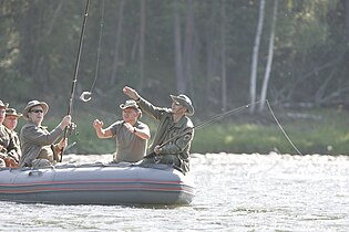 Путин (справа) рыбачит на реке Енисей во время сплава вместе с князем Монако Альбером II (слева) и Шойгу. Тыва, 13 августа 2007 года