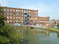 Duke Mill with its original reservoir as seen from the east side of the building. The reservoir today is separately owned and used for licensed fishing.