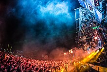 An EDM festival in 2013 in Plainfeld, Austria with over 100,000 attendees, exhibiting the large crowds and dramatic lighting common at such events since the early 2000s. Electric Love 2013.jpg