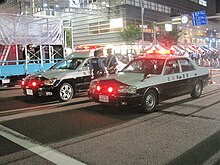 Ishikawa Prefectural Police officers with their police cars. Japanese police are managed and coordinated by the National Police Agency, and divided into agencies for their respective prefectures. Ishikawa Police Crown.jpg