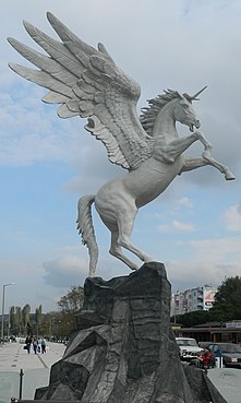 Sculpture vue de profil droit, représentant un cheval cabré sur un rocher avec une courte corne et de larges ailes.