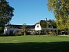 De Nieuwenkamp. Boerderij met landheerkamer en dwars op het hoofdgebouw staande stal. Kwam in 1884 in bezit van Van Coeverden, de eigenaar van langgoed Overvelde. Opgedeeld in twee woningen met twee bakhuisjes