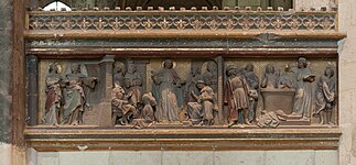 Bas-relief représentant, de gauche à droite, un ange aux côtés de saint Quentin, saint Quentin prêchant devant une dizaine de personnes, saint Quentin à côté de deux hommes plongés dans une bassine d'eau.