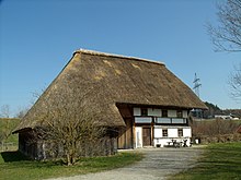 Maison avec un imposant toit de chaume de roseau
