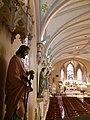 View of the statues of the apostles the line the clerestory level of the church nave with the sanctuary in the distance.