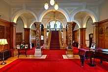 Entrance hall of the residence, with parquet floors and oak panellings used prominently throughout. Taupaepae, Government House.jpg